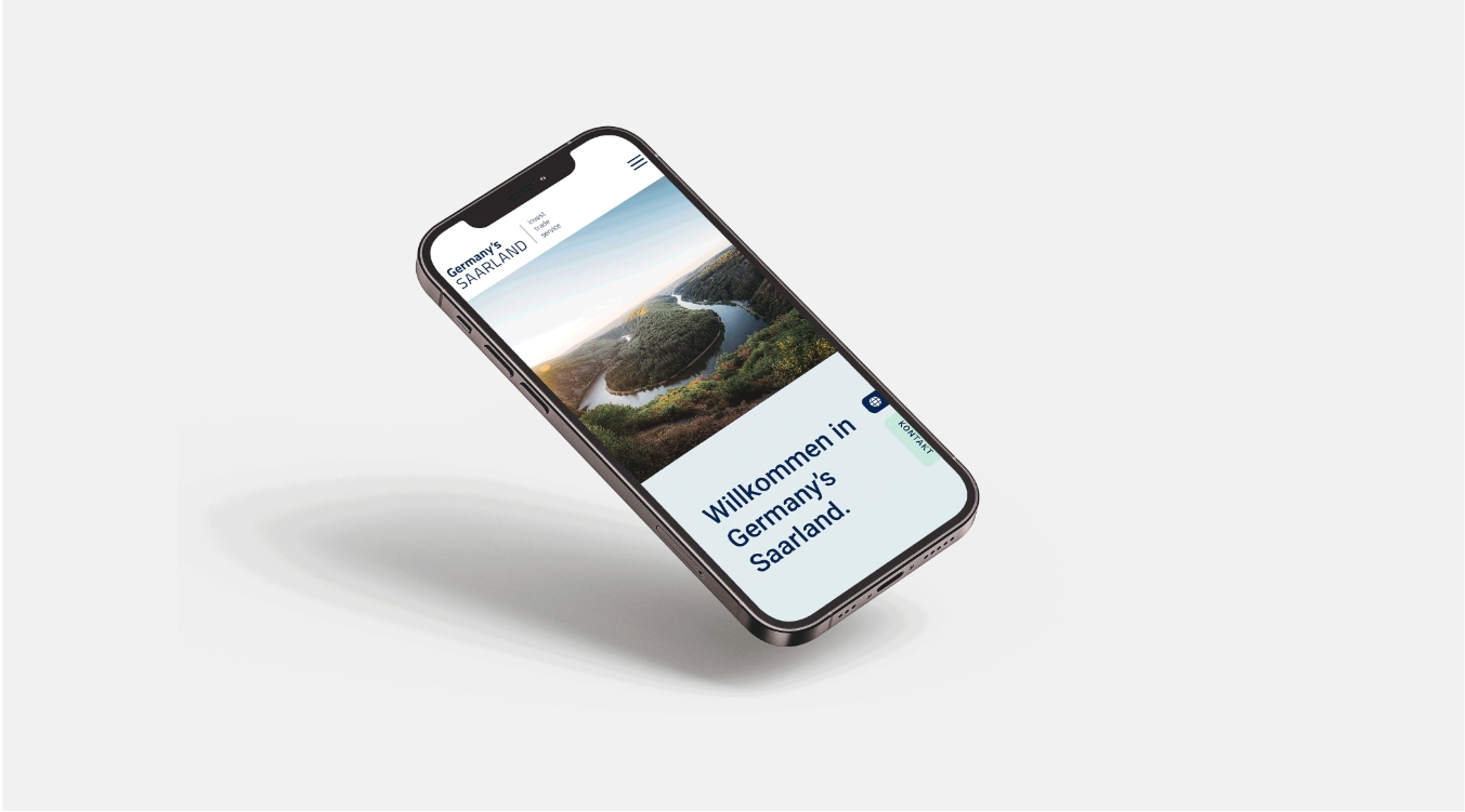 Smartphone-Mockup mit der mobilen Website, Startseite mit Saarschleife und Slogan ‚Willkommen in Germany’s Saarland